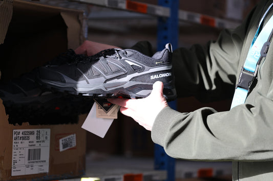 Préparation de commandes d’équipement sportif : opérateur ReGNR effectuant le picking d'une paire de chaussures Salomon en entrepôt.