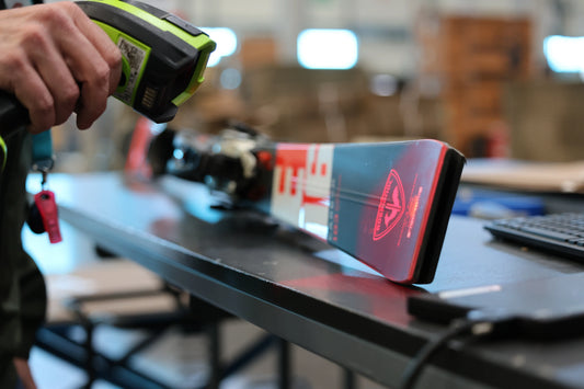 Opérateur logistique ReGNR scannant une paire de skis Rossignol pour le contrôle et l'intégration des stocks WMS